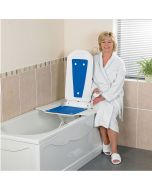 Woman smiling while using the Bathmaster Deltis Reclining Bath Lift with remote control installed in bath.